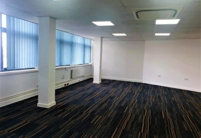 Corner office suite with blue patterned carpet and ample natural light.