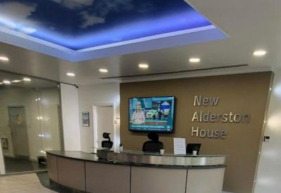 Sleek reception desk under a feature ceiling with a blue sky and cloud mural.