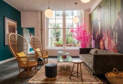 Stylish reception or waiting area with high-back wicker chairs and a large wall mural.