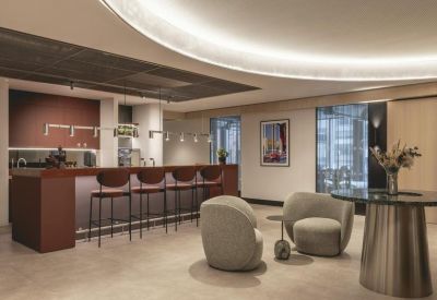 Bistro-style communal kitchen with a wood-fronted breakfast bar and stylish leather stools.