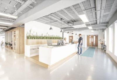 Open-plan coworking area with high-top tables and natural light from large windows.