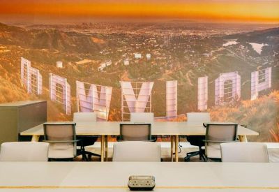 Long workstation table in front of a vibrant wall mural depicting a city landscape.