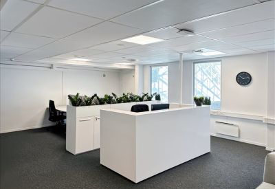Clean white reception area or lobby with integrated planters and a minimalist white desk.