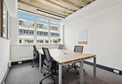 Modern meeting space featuring a central wooden table and minimalist white walls.