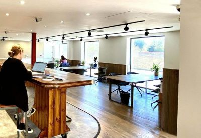 Modern open-plan workspace with a high timber breakfast bar and multiple desk configurations.