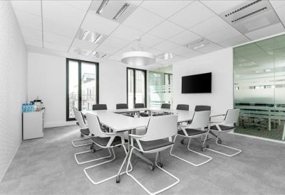 Modern reception area with a minimalist stone-finish front desk and sleek white storage panels.