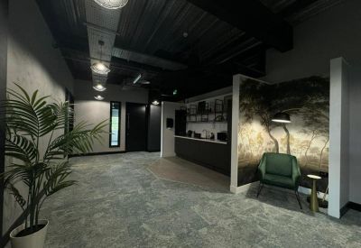 Industrial style reception area with a feature wall and dark ceiling.