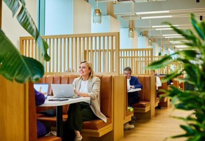 Private wooden booths with leather seating and people working on laptops.