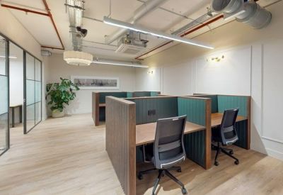 Modern dedicated desk area with wooden dividers and ergonomic chairs.