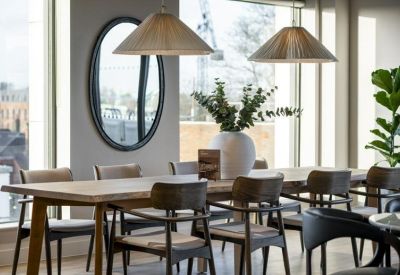 Stylish dining area featuring a large round mirror and potted greenery.