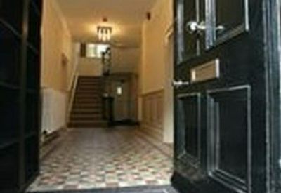 Grand entrance hallway with checkered tile flooring and an elegant staircase.
