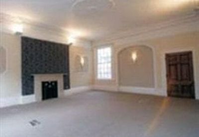 Spacious open-plan room with a feature fireplace and decorative ceiling molding.