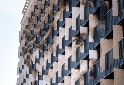 Portrait exterior view of Nemunas Aparthotel, 1 Liepų gatvė featuring a striking face mural on the facade.