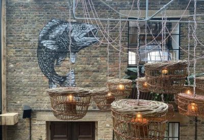 Exposed brick wall featuring a large fish mural and hanging woven basket lights.