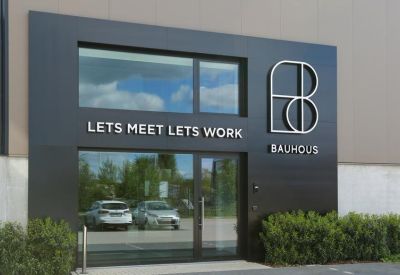 Main entrance of the building featuring bold black signage and glass doors.