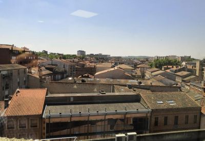 High-angle view of traditional terracotta rooftops under a clear blue sky.