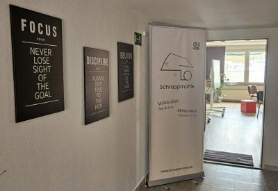 White hallway featuring motivational wall art and a large informational banner.