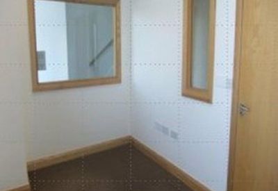 Small reception area or office nook with internal glass viewing panels and a wooden door.