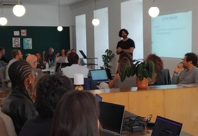 A live workshop presentation in a bright office space with modern pendant lighting.