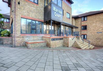 Main entrance of the brick building with stone steps and signage.