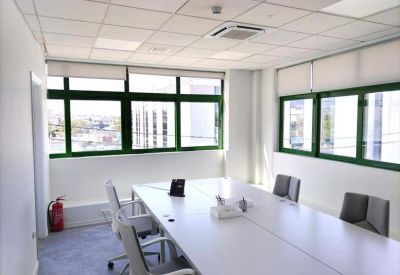 Bright conference room with a large white table and floor-to-ceiling windows.