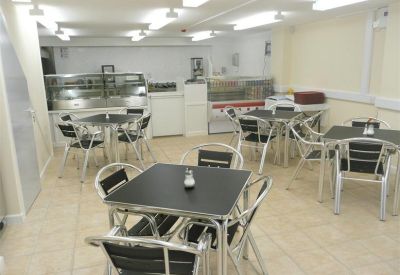 On-site cafe area with several tables, chairs, and a serving counter.