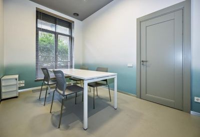 Small private office with a white desk, grey chairs, and a wall featuring a green-to-white gradient.