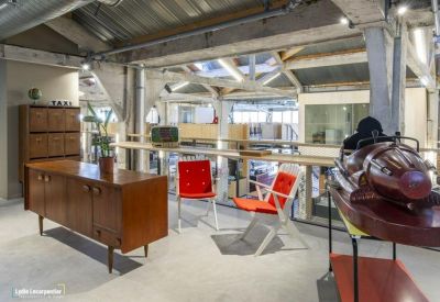 Breakout area with mid-century modern furniture, red chairs, and architectural wooden beams.