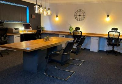 Spacious co-working office at 10, Sampson Road North with warm pendant lighting and wooden desks.