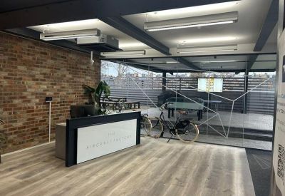 Modern reception area with a brick wall and outdoor terrace access.