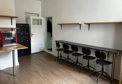 Communal break area with high-top seating, wooden floors, and a small snack station.