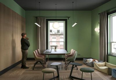 Bright meeting room with green walls, a round table, and cozy dog beds.