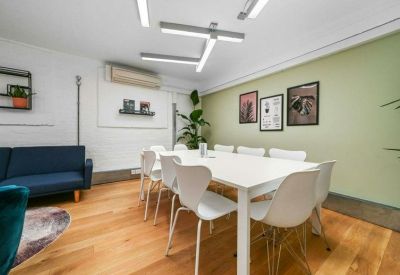 Long white conference table with modern seating under geometric light fixtures.