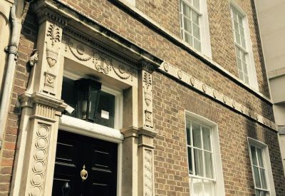 Close-up of the ornate stone entrance at 11 Golden Square, Central London, W1F.