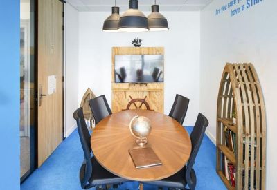 Themed meeting room with a boat-shaped bookshelf, nautical decor, and blue carpeting.