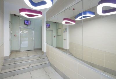 Bright building entrance with geometric pendant lights and mirrored wall.