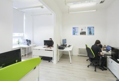 Open-plan office space with divided workstations and natural light.