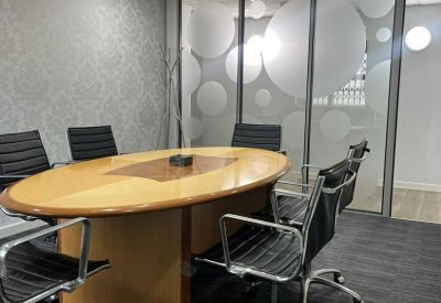 Professional boardroom with a large wooden table and bubble-patterned glass walls.