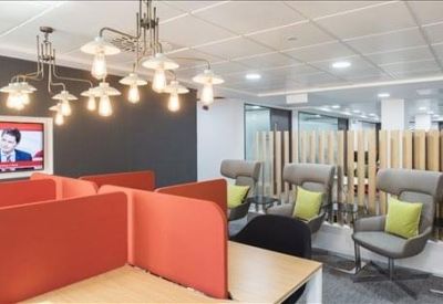 Breakout area with orange privacy screens, lounge chairs, and a decorative light fixture.