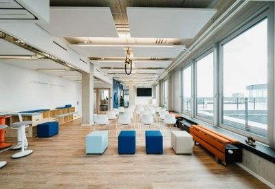 Versatile event space with colorful seating cubes and a presentation screen.