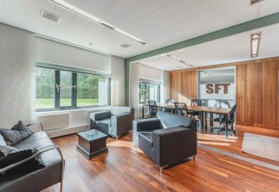 Private office suite with black leather armchairs and a large window.