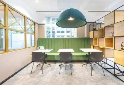 Modern seating area with a green feature wall, wooden shelving, and a large dome pendant light.