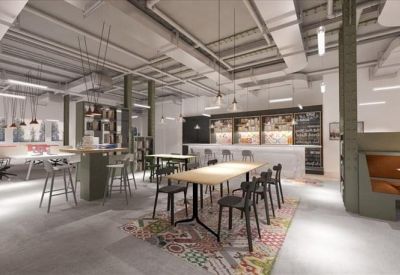 Modern cafeteria area with high tables, stools, and a sleek kitchen counter.