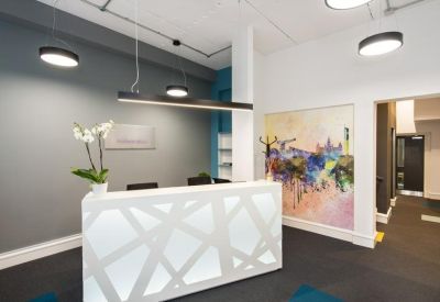 Bright reception area featuring a geometric white desk and colorful artwork.