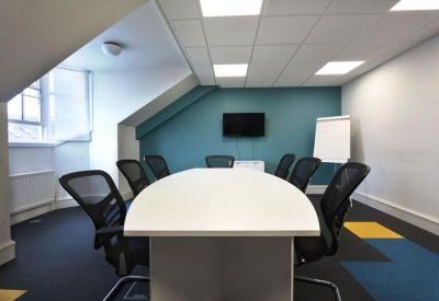 Sleek meeting room with a white oval table, mesh chairs, and a teal accent wall.