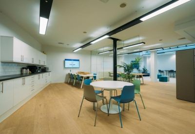 Modern communal kitchen and break area with colorful seating at 127, Portland Street.