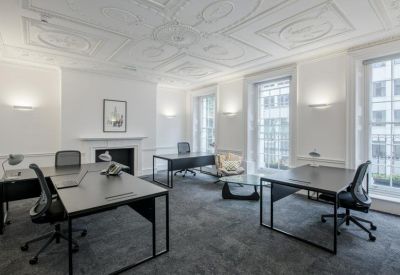 Spacious private office suite with dark wood desks and an ornate patterned ceiling.