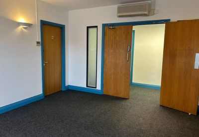 Spacious reception area with blue trim and double wooden doors.