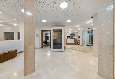 Bright marble-floored lobby area with a glass entrance and seating.