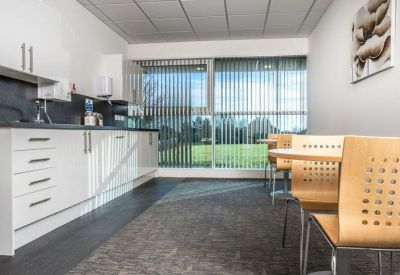 Contemporary kitchen and dining area with white cabinetry and a garden view.